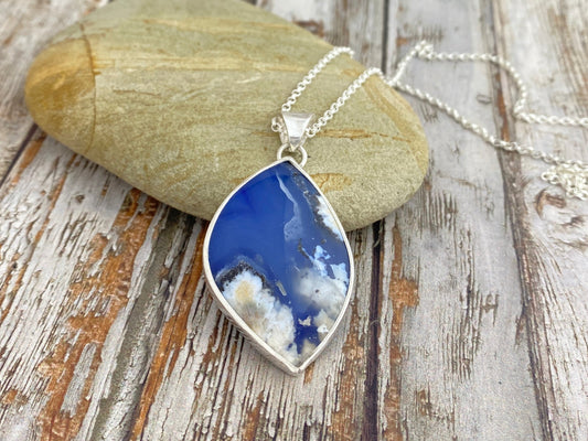 Necklace with a blue pendant on a wooden surface