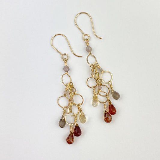 Gold earrings with dangling gemstones on a white background